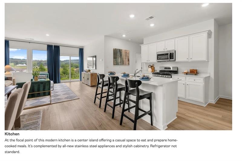 Kitchen with open floor plan, a kitchen bar, white cabinetry, stainless steel appliances, and recessed lighting