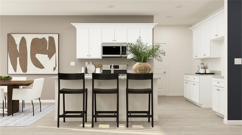 Kitchen featuring a breakfast bar, white cabinetry, stainless steel microwave, and light wood-style flooring
