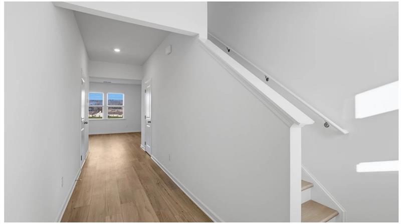 Hallway featuring light wood finished floors and recessed lighting